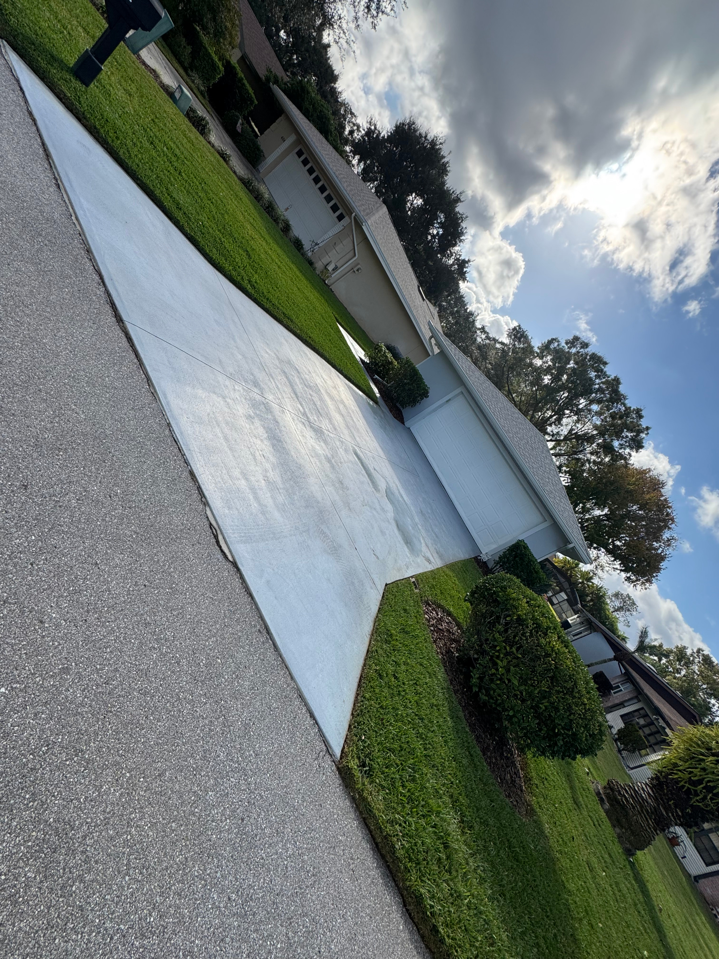 Pressure-washed driveway leading to a tidy Florida home